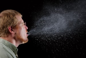 2009 Brian Judd This 2009 photograph captured a sneeze in progress, revealing the plume of salivary droplets as they are expelled in a large cone-shaped array from this mans open mouth, thereby, dramatically illustrating the reason one needs to cover hios/her mouth when coughing, or sneezing, in order to protect others from germ exposure. How Germs SpreadIllnesses like the flu (influenza) and colds are caused by viruses that infect the nose, throat, and lungs. The flu and colds usually spread from person to person when an infected person coughs or sneezes.How to Help Stop the Spread of GermsTake care to: - Cover your mouth and nose when you sneeze or cough - Clean your hands often - Avoid touching your eyes, nose or mouth - Stay home when you are sick and check with a health care provider when needed - Practice other good health habits.